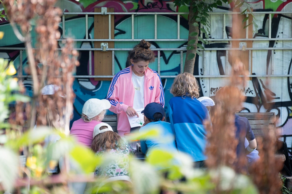 Kinder hören einer Leitperson zu